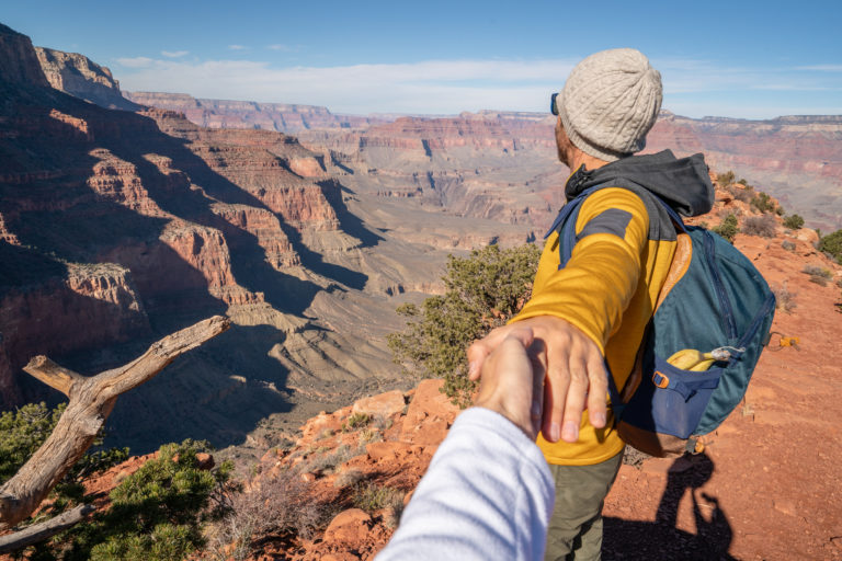 follow-me-to-concept-young-man-leading-girlfriend-to-the-grand-canyon-enjoying-travel-in-the-usa