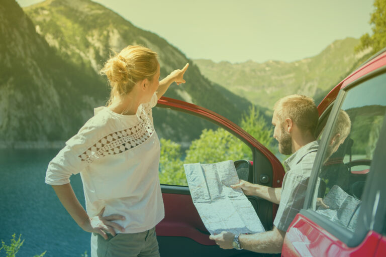 young-couple-on-road-trip-reading-a-map-for-directions-summer-3