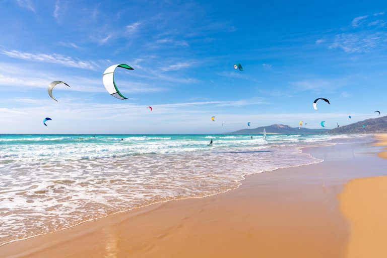 tarifa-beach-in-cadiz-surf-city-skyline-of-andalusia-spain-with-lots-of-kitesurfing-kites-sunny-sky